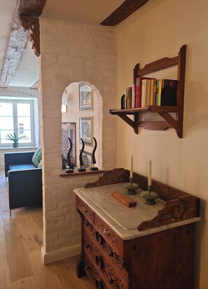 A room with a wooden cabinet, a bookshelf, and a window with a view. - Newly Renovated Apartment in the Old Town (Landsberg am Lech)