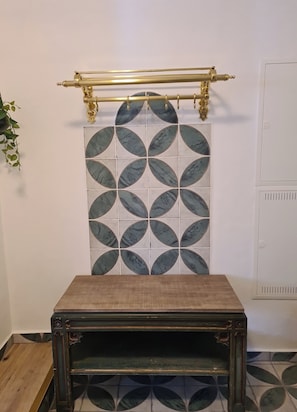 Une pièce avec un mur orné de motifs, une table en bois et un radiateur.