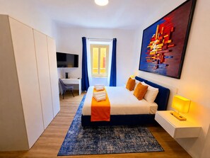 Habitación de hotel moderna con cama, escritorio y un cuadro abstracto grande.