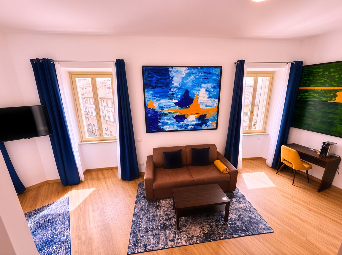 A living room with a sofa, coffee table, and artwork on the walls.