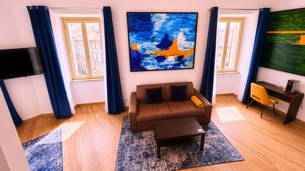 A living room with a sofa, coffee table, and artwork on the walls.