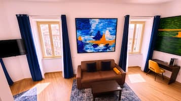 A living room with a sofa, coffee table, and artwork on the walls.
