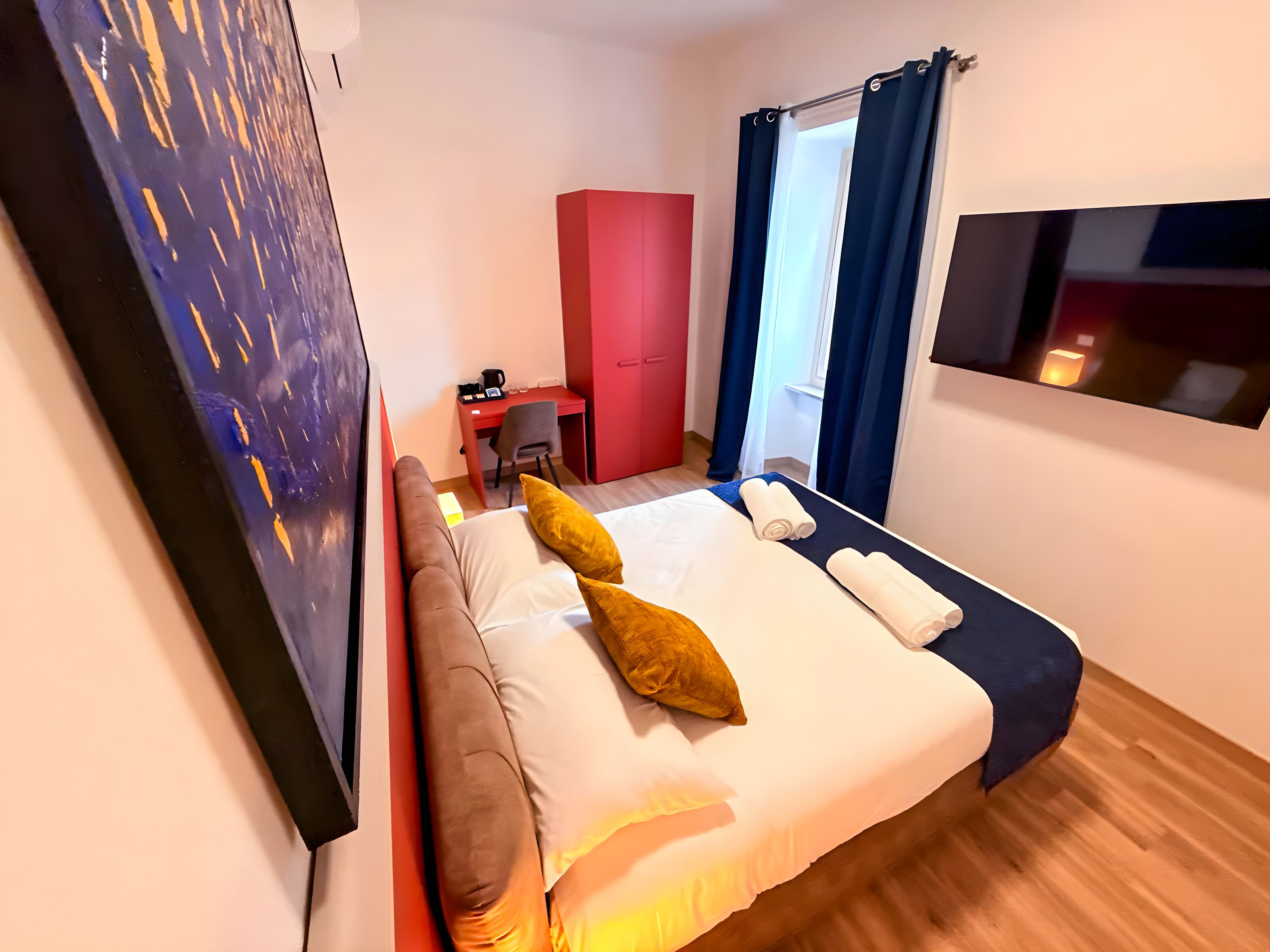 Een hotelkamer met een bed, een bureau, een stoel en een kledingkast.
