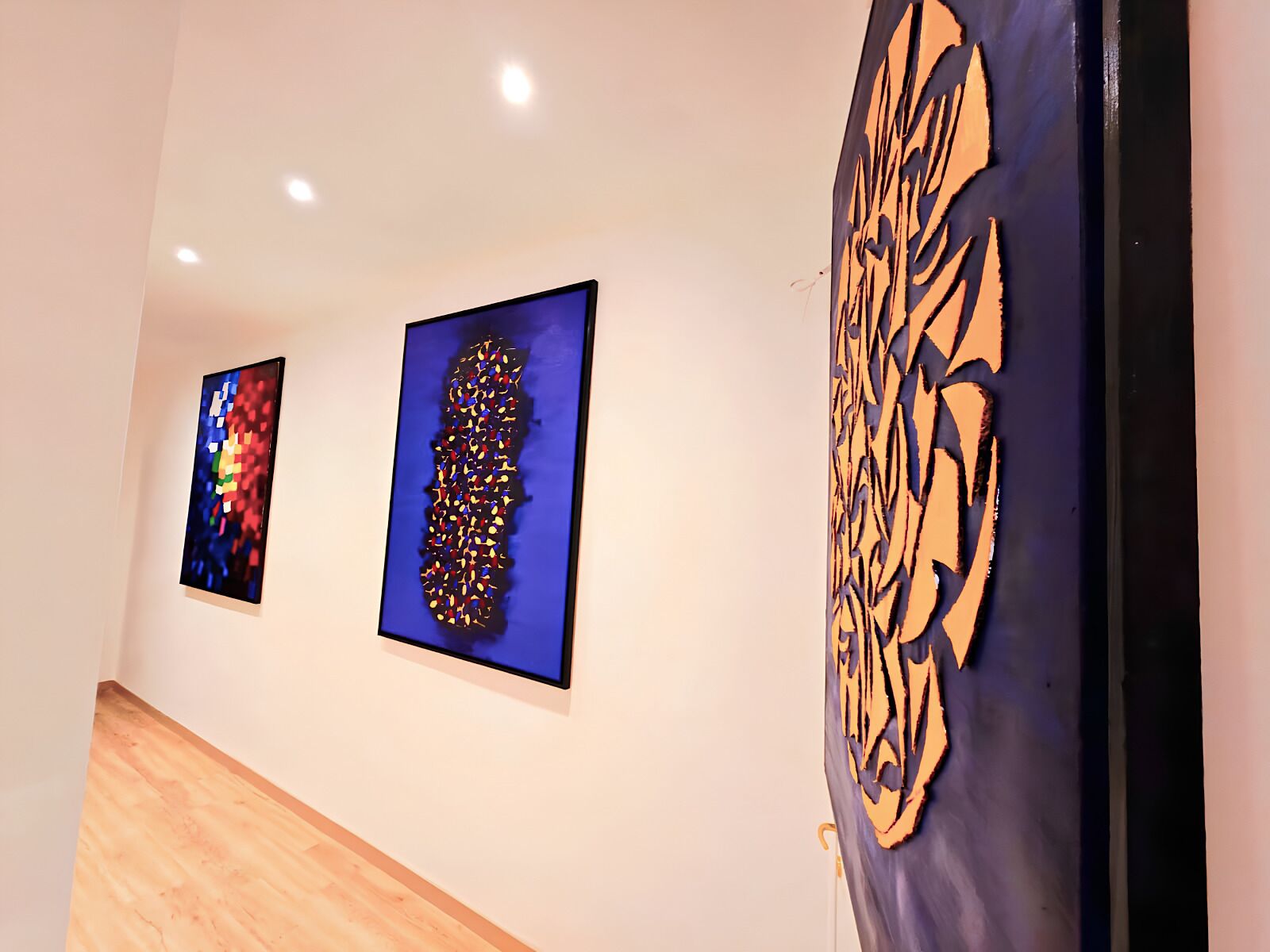 A hallway with three artworks on the wall.