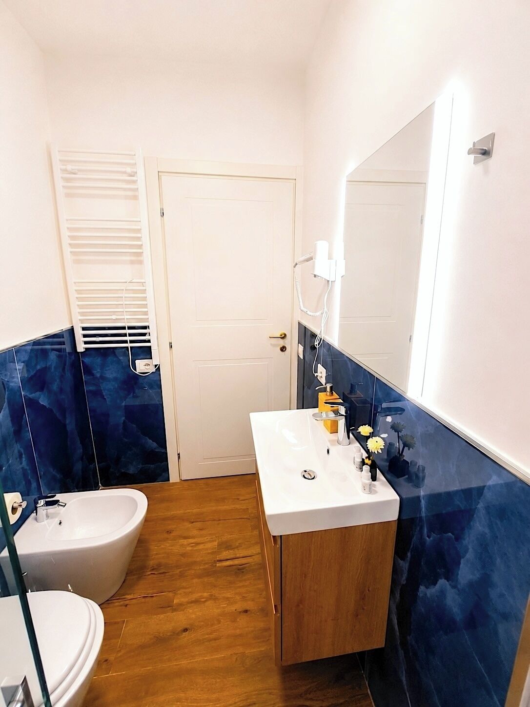 Une salle de bain avec un lavabo blanc, des toilettes et un bidet.