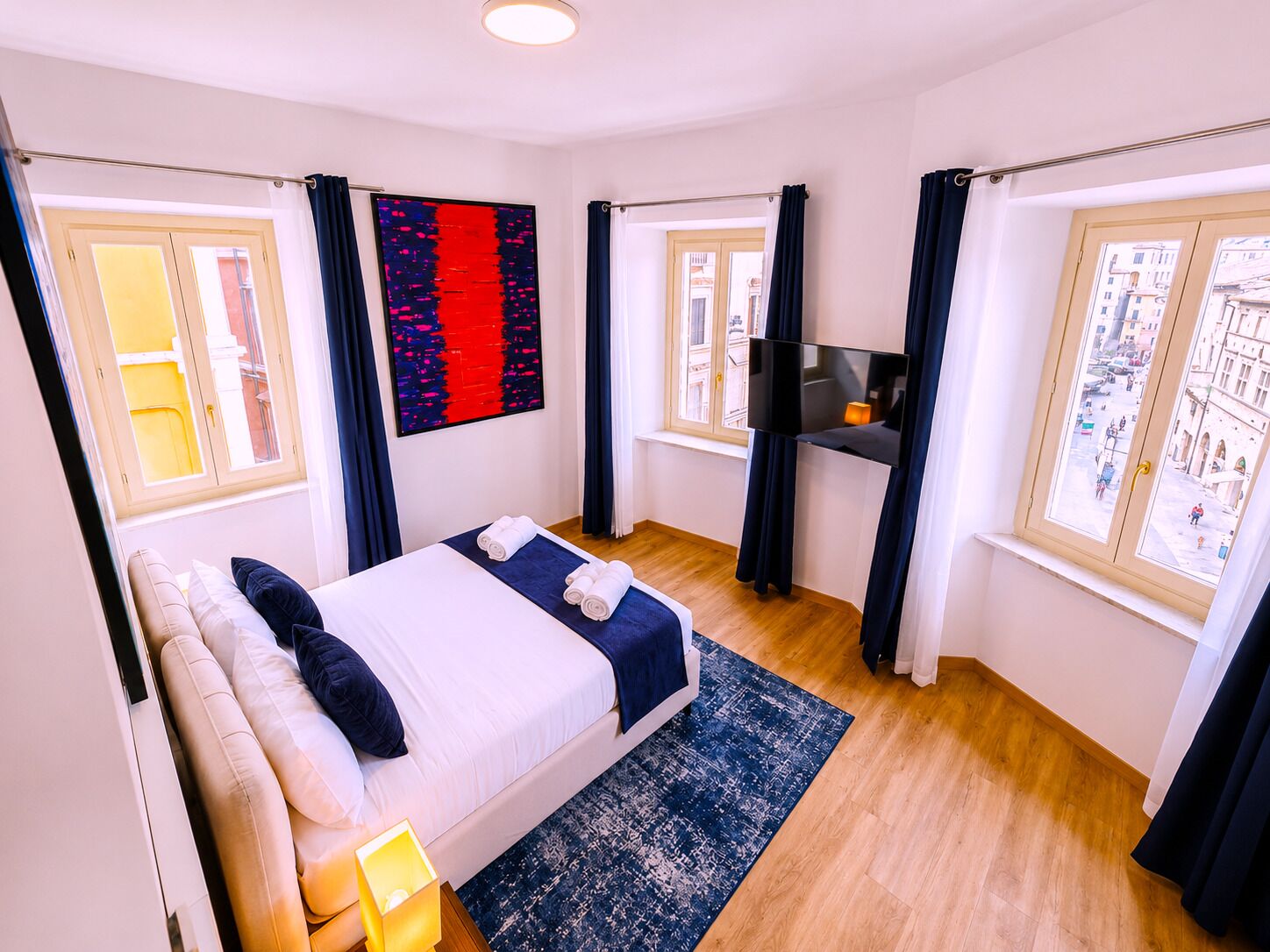 Une chambre d’hôtel avec un lit, une télévision et une vue sur la ville.