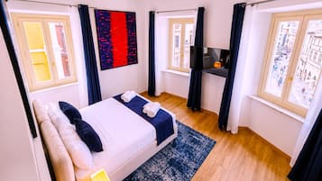 Une chambre d’hôtel avec un lit, une télévision et une vue sur la ville.