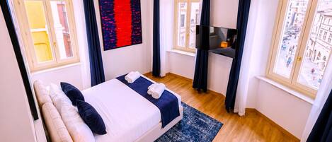 Una habitación de hotel con cama, televisión y vista a la ciudad.