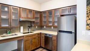 A modern kitchen with wooden cabinets, stainless steel appliances, and a dishwasher. - ADA 2BR Suite w/ Accessible Tub | Free Breakfast! (Davie)