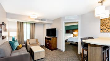 Une chambre d’hôtel avec un canapé, une télévision, un bureau et un lit.