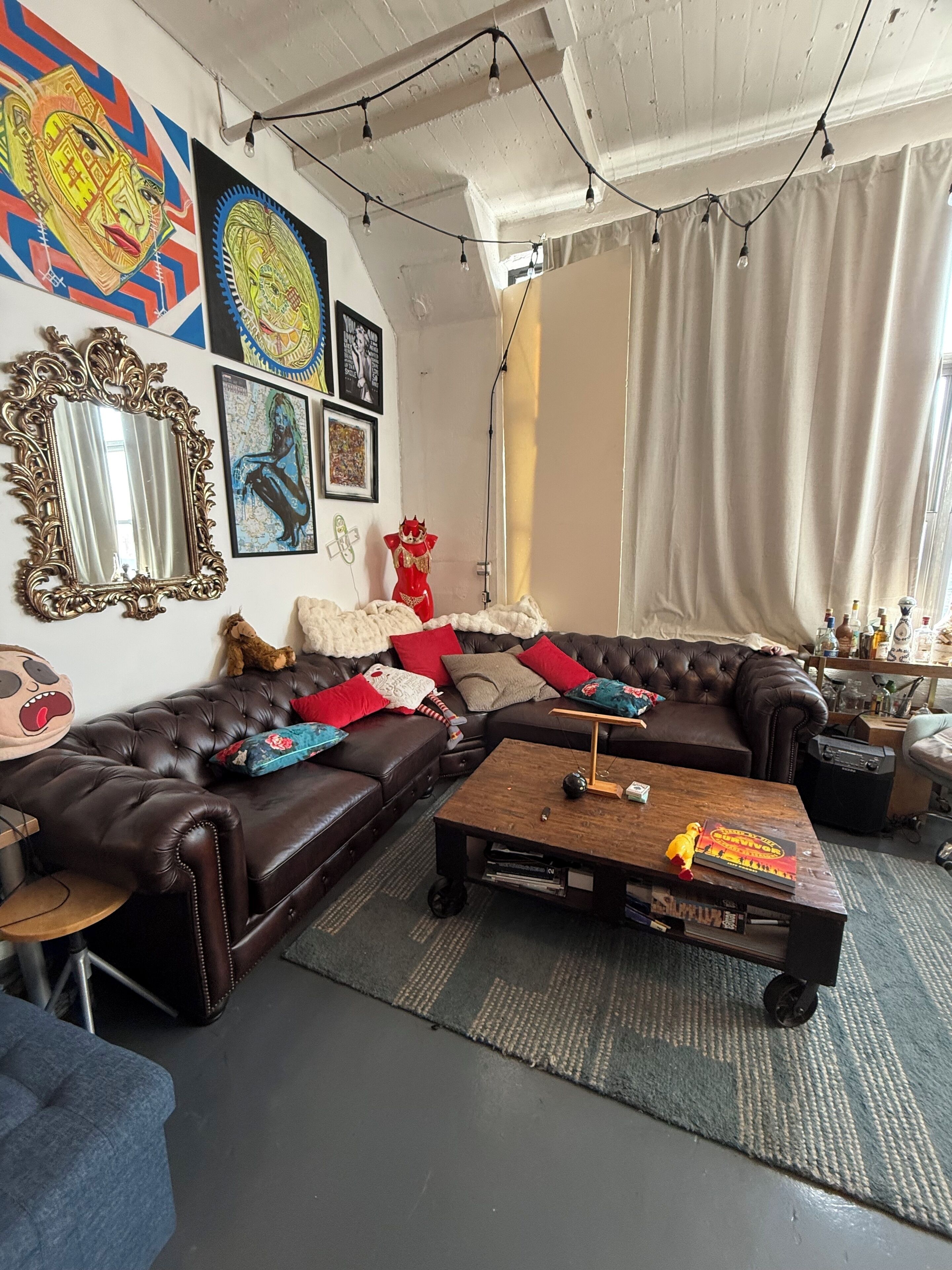 Ein Wohnzimmer mit einem braunen Ledersofa, einem Holztisch und einem großen Spiegel.