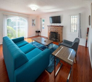A living room with a sofa set, a coffee table, a fireplace, and a TV. - Bright 3 bedroom Venice House, Short Walk to Beach (Los Angeles)