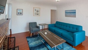 A living room with a sofa, a coffee table, a chair, and a fireplace. - Bright 3 bedroom Venice House, Short Walk to Beach (Los Angeles)