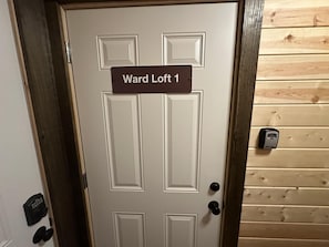 Uma porta com uma placa indicando 'Ward Loft 1' e uma fechadura digital.