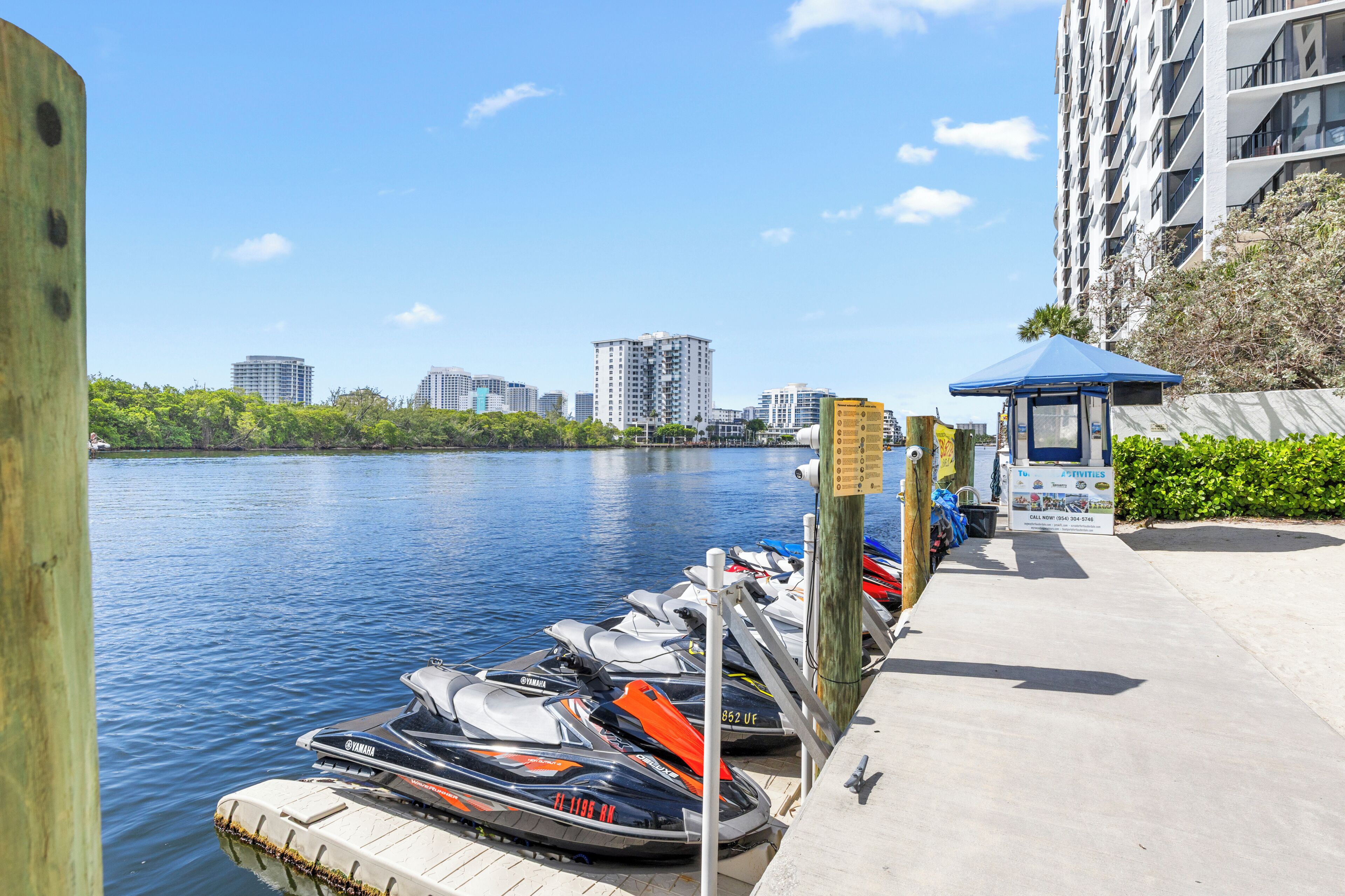 Un jet ski amarrado en un muelle, con un horizonte urbano de fondo.