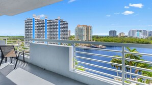 Uma varanda com vista para uma marina e edifícios altos.