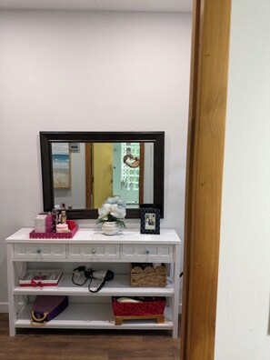A white vanity with a mirror, a framed photo, and various toiletries. - Spacious 2 bedroom house in fabulous Key Largo with AC. Mile 100 1/2 from US1 (Key Largo)
