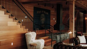Interior de madera con una escalera, un letrero que dice 'STATE OF OREGON' y una chimenea.