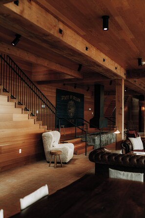 Interior de madera con una escalera, un letrero que dice 'STATE OF OREGON' y una chimenea.