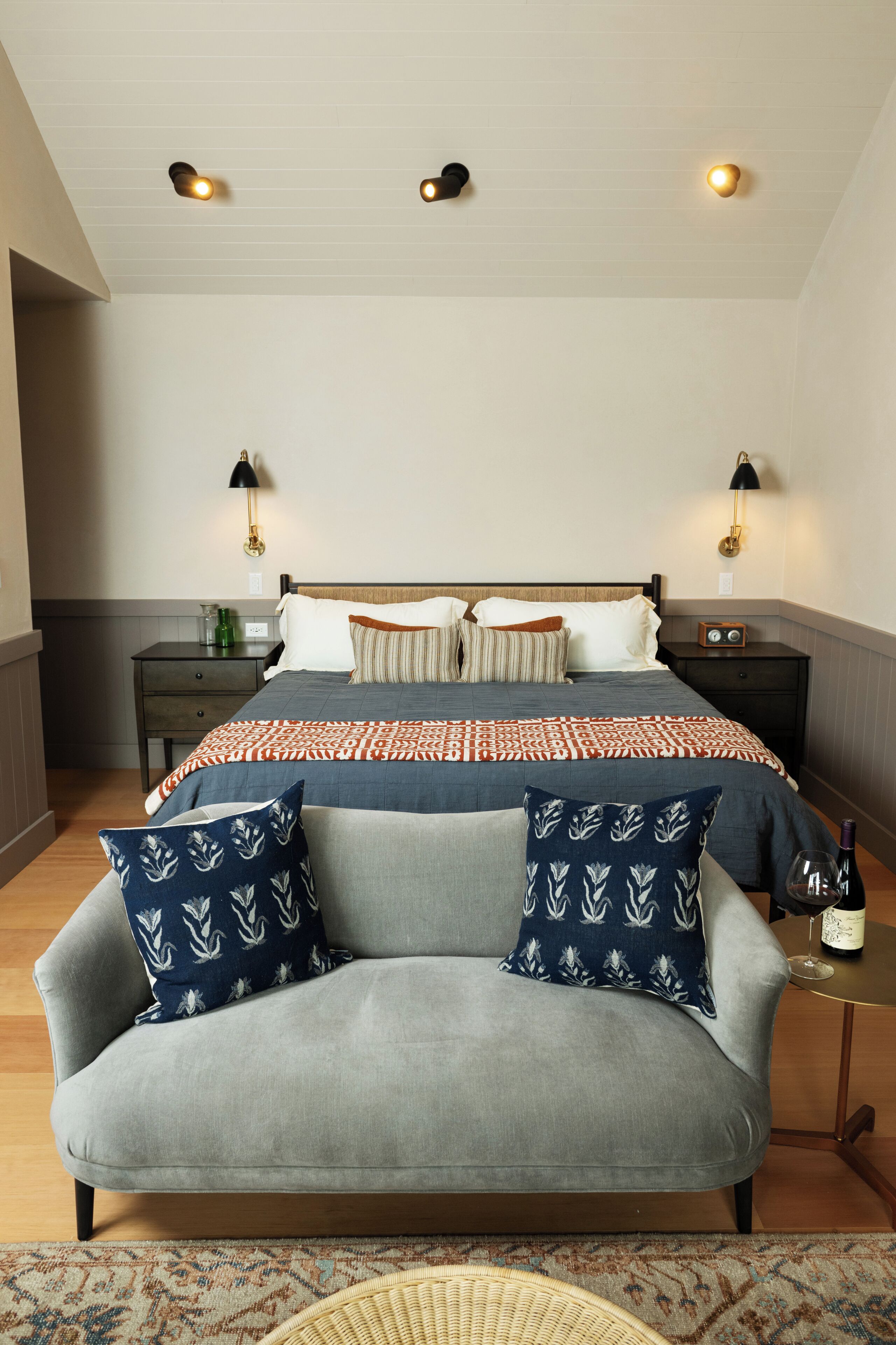 Ein Schlafzimmer mit einem Bett, einem Schlafsofa, zwei Nachttischen und einer Lampe.
