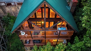 Eine Holzhütte mit Balkon, Whirlpool und Essbereich.