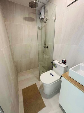 A modern bathroom with a glass-enclosed shower, a toilet, and a sink. - Modern Container Stay Near Pratumnak Beach 1 (Muang Pattaya)
