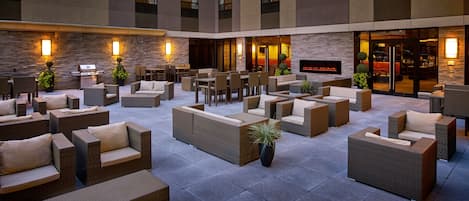 A spacious outdoor seating area with wicker furniture and stone walls.