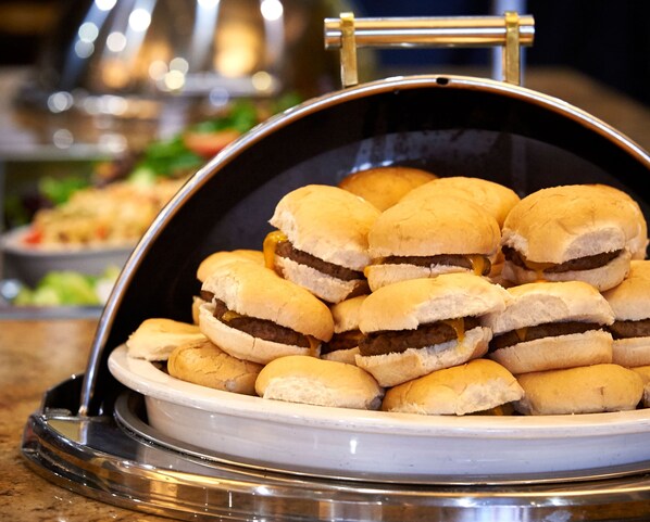 Un bufé con una variedad de alimentos, incluyendo sándwiches y otros platos.