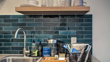 Coffee/tea maker, microwave, cookware/dishes/utensils, dining table
