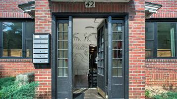A building entrance with a numbered door, a mailbox, and a small step leading up to the door.
