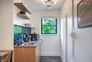 A compact kitchen with a window, a sink, and a coffee maker. - Sabel #201 | Downtown Asheville king suite with parking, Wi-Fi, and smart TV. (Asheville)