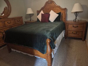 A bedroom with a wooden bed, two nightstands, a dresser, and a mirror. - Chimney Rock view 3-bedroom cabin with hot tub in charming Lake Lure on mountain (Lake Lure)