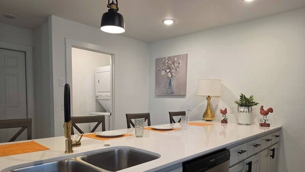 A modern kitchen with a double sink, white cabinets, and a dishwasher. - Modern OKC Duplex | Close to OU Med & Downtown (Oklahoma City)