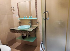 A bathroom with a glass sink, a mirror, and a shower door. - Old city apart hotel (Batumi)