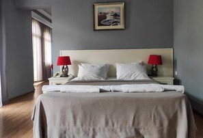 Un dormitorio con una cama, dos mesitas de noche, una lámpara y un cuadro en la pared.