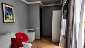 Suíte, sacada, vista para a cidade | Área de estar