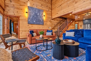Un interior de madera con un sofá, una mesa de centro y un sofá azul.