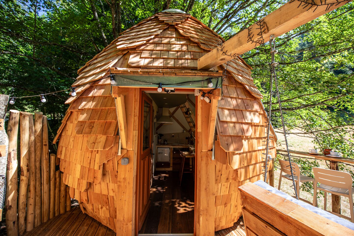 Une cabane en bois avec un toit en pente, une porte et un petit porche.