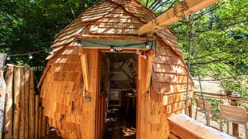 Une cabane en bois avec un toit en pente, une porte et un petit porche.