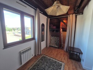 A room with a wooden ceiling, a zebra-patterned rug, a radiator, and a window with curtains. - Charmante maison à Sundhoffen classée 3 clés parfaite pour des séjours reposants (sundhoffen)