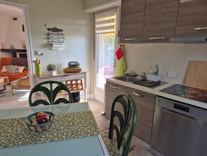 Una cocina moderna con lavavajillas, un lavamanos y una encimera con tabla de cortar.