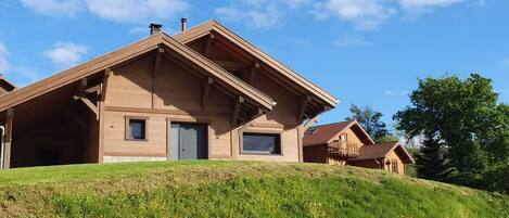 A wooden cabin with a sloped roof, a front door, and a small window.