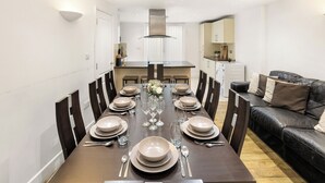 A dining room with a long table set for a meal, flanked by chairs. - Exquisite 4BR Home 15 Guests Prime Central London (London)