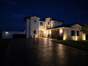 A two-story house with a driveway leading to a garage.