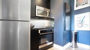 A modern kitchen with stainless steel appliances, a microwave, oven, and a trash can. - Designer 3BR • Two Levels • 2.5 BTHR (Montréal)