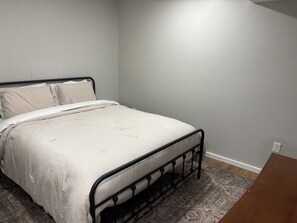 A single bed with a metal frame, a patterned rug, and a plain wall. - Fresh and Modern Lake House Steps to the Water! (Dry Ridge)
