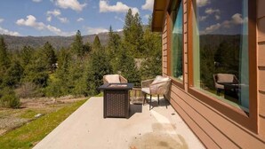 A patio with outdoor furniture, a large window, and a view of a forested area. - Ponerosa Nest-Quails Nest 1hr Drive to Yosemite (Mariposa County)