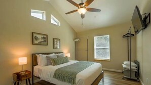 A bedroom with a bed, bedside lamps, a ceiling fan, a window, and a wall-mounted TV. - Ponderosa Nest-BlueJay Nest 1hr drive to Yosemite (Mariposa County)