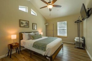 A bedroom with a bed, bedside lamps, a ceiling fan, a window, and a wall-mounted TV. - Ponderosa Nest-BlueJay Nest 1hr drive to Yosemite (Mariposa County)
