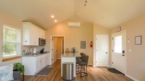 A spacious kitchen with white cabinets, a microwave, and a small island with bar stools. - Ponderosa Nest-BlueJay Nest 1hr drive to Yosemite (Mariposa County)